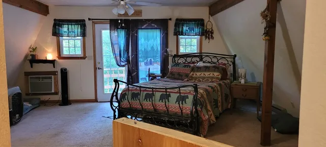 a bedroom with a bed next to a window