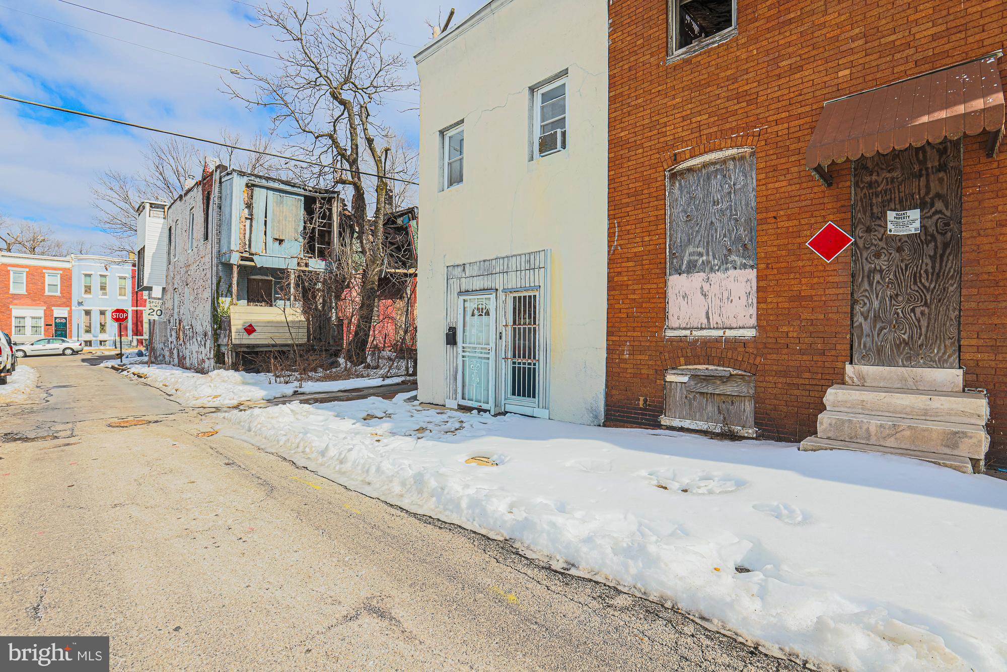 633 North Brice Street Baltimore, MD 21217 - Photo 3 of 28 Abandoned homes along a snowy street.