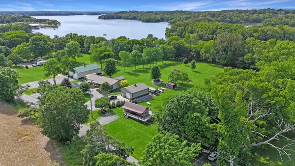 an aerial view of green landscape with trees houses and lake view