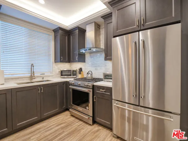 a kitchen with stainless steel appliances granite countertop a refrigerator and a sink