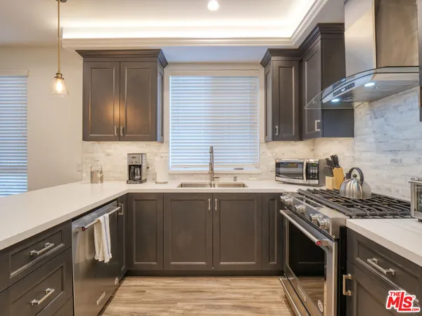 a kitchen with stainless steel appliances granite countertop a sink stove and cabinets