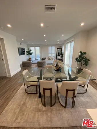 a living room with stainless steel appliances kitchen island granite countertop furniture and a wooden floor