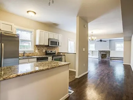 a large kitchen with a center island appliances and cabinets