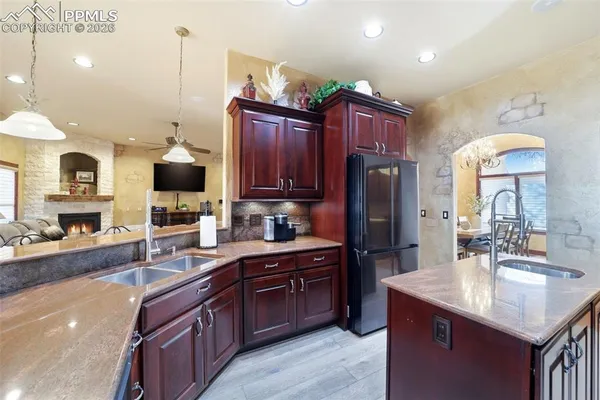 a kitchen with granite countertop a sink cabinets and stainless steel appliances