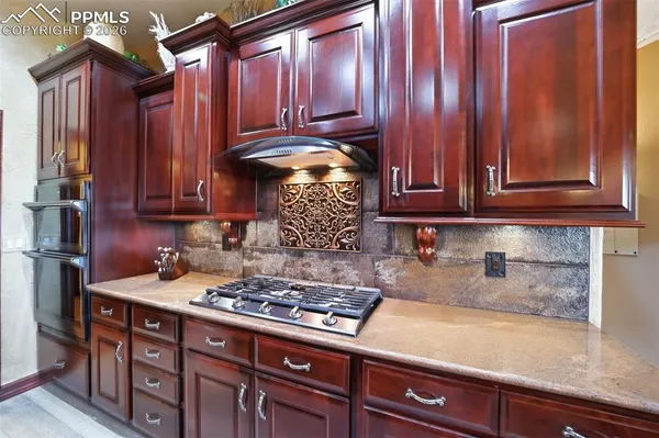 a kitchen with granite countertop wood cabinets and stainless steel appliances