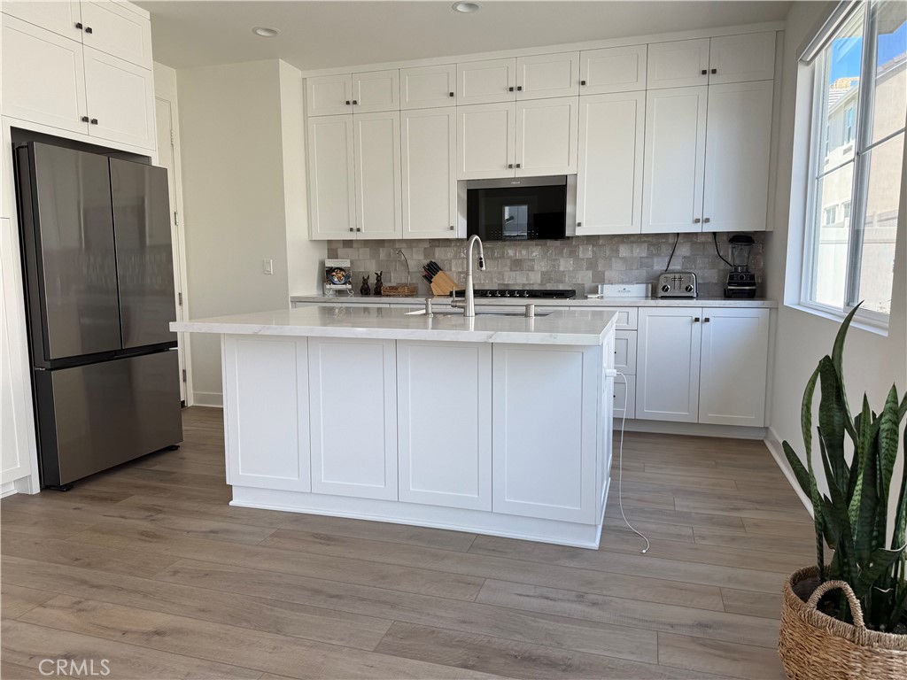 541 Jasper Street Rancho Mission Viejo, CA 92694 - Photo 3 of 20 a kitchen with white cabinets stainless steel appliances and a potted plant