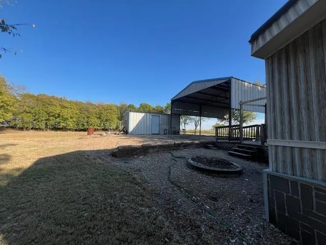a backyard of a house with lawn chairs under an umbrella