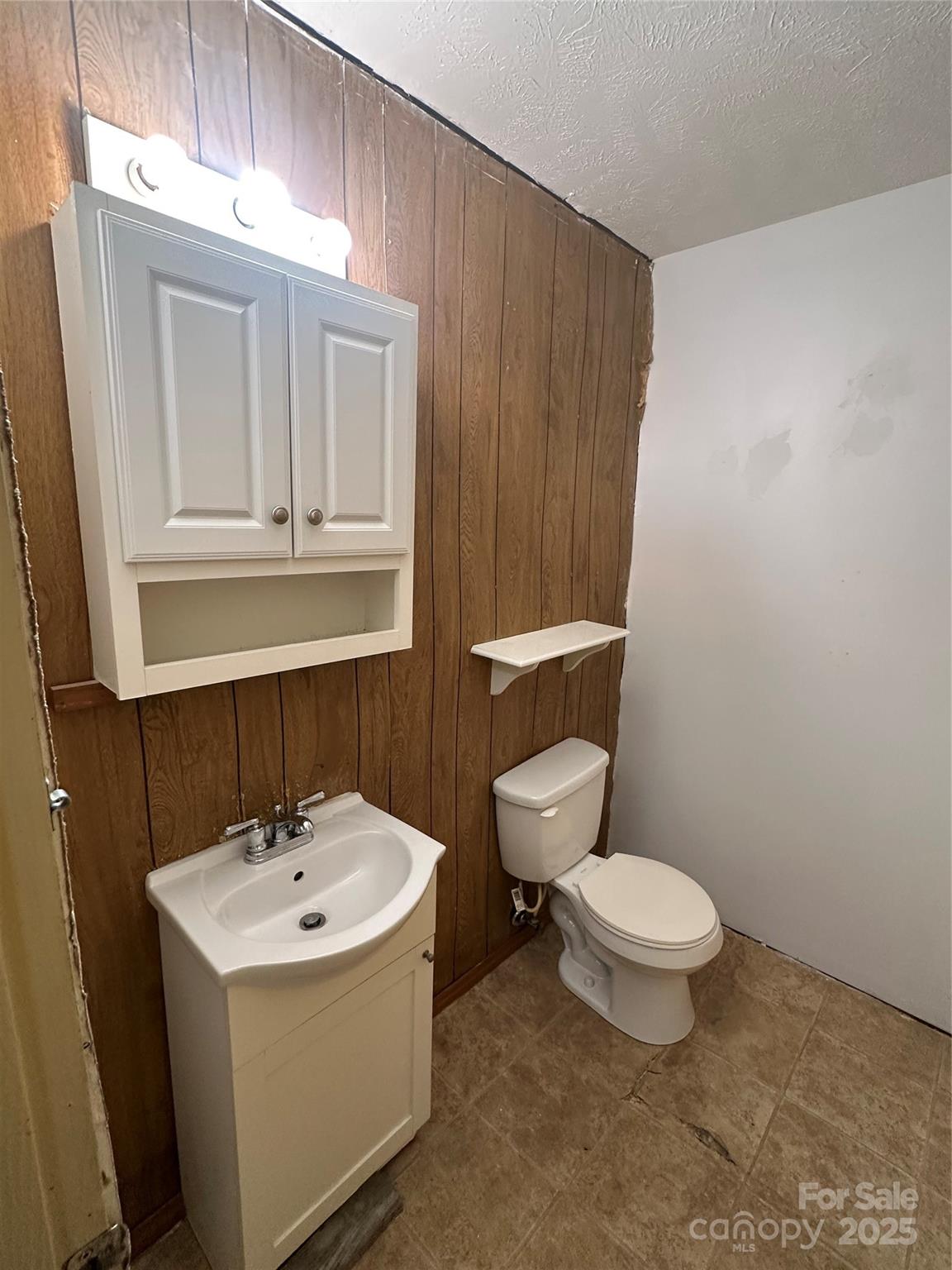 1014 Rockingham Road Rockingham, NC 28379 - Photo 6 of 8 a bathroom with a sink a toilet and mirror