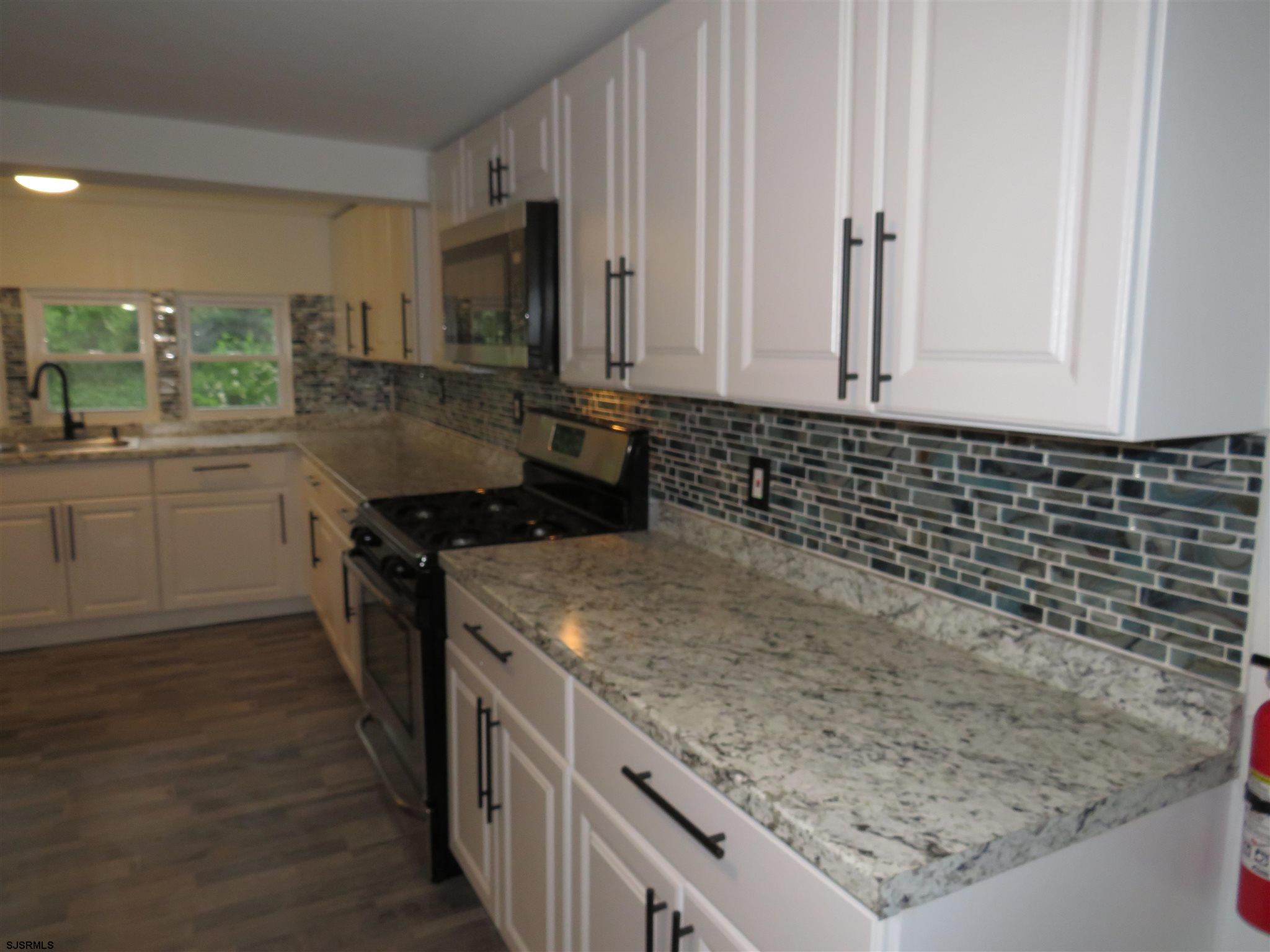 1702 Somers Point Road Egg Harbor Township, NJ 08234 - Photo 11 of 25 a kitchen with stainless steel appliances granite countertop a sink stove and cabinets