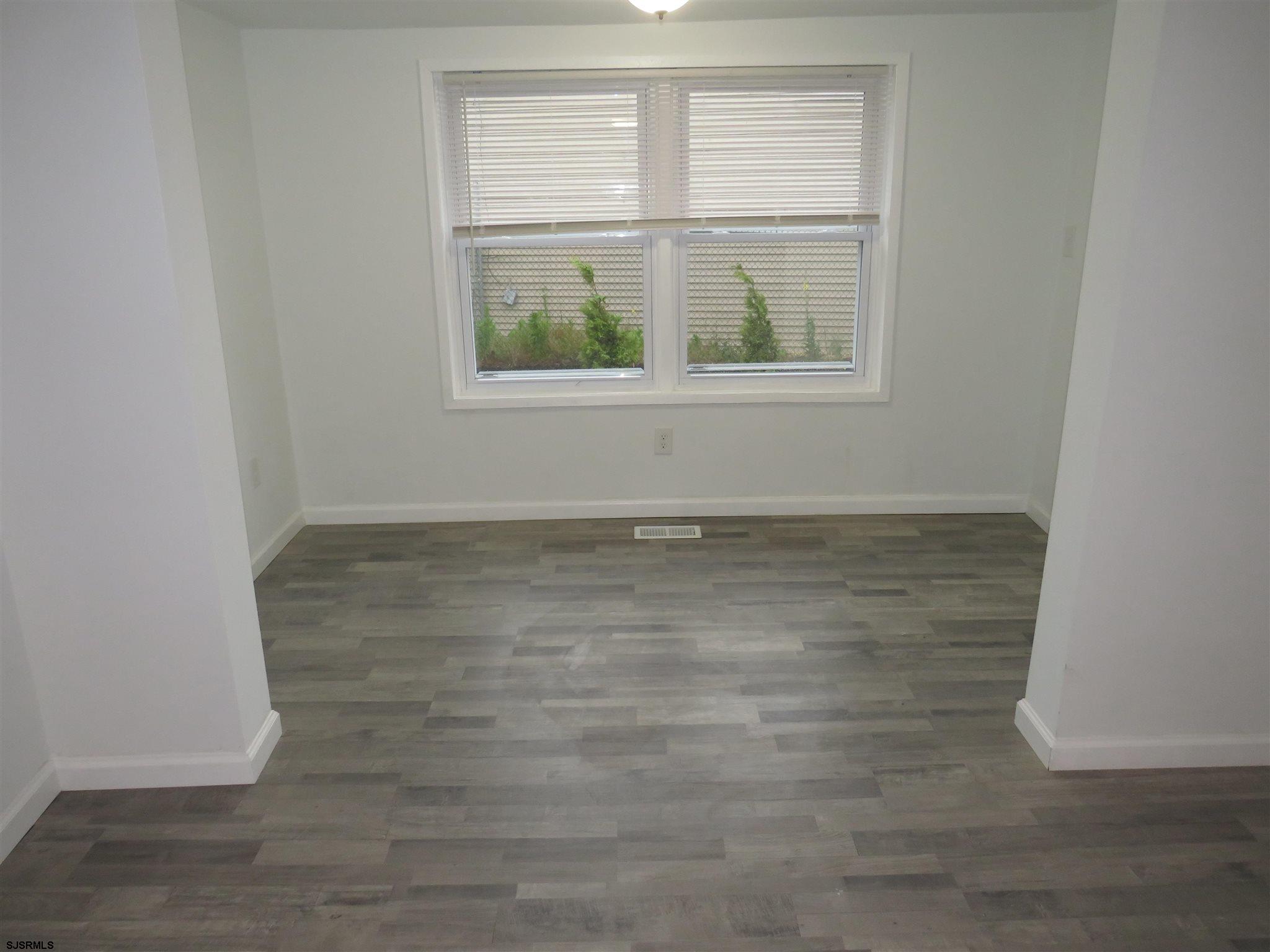 1702 Somers Point Road Egg Harbor Township, NJ 08234 - Photo 13 of 25 an empty room with wooden floor and windows