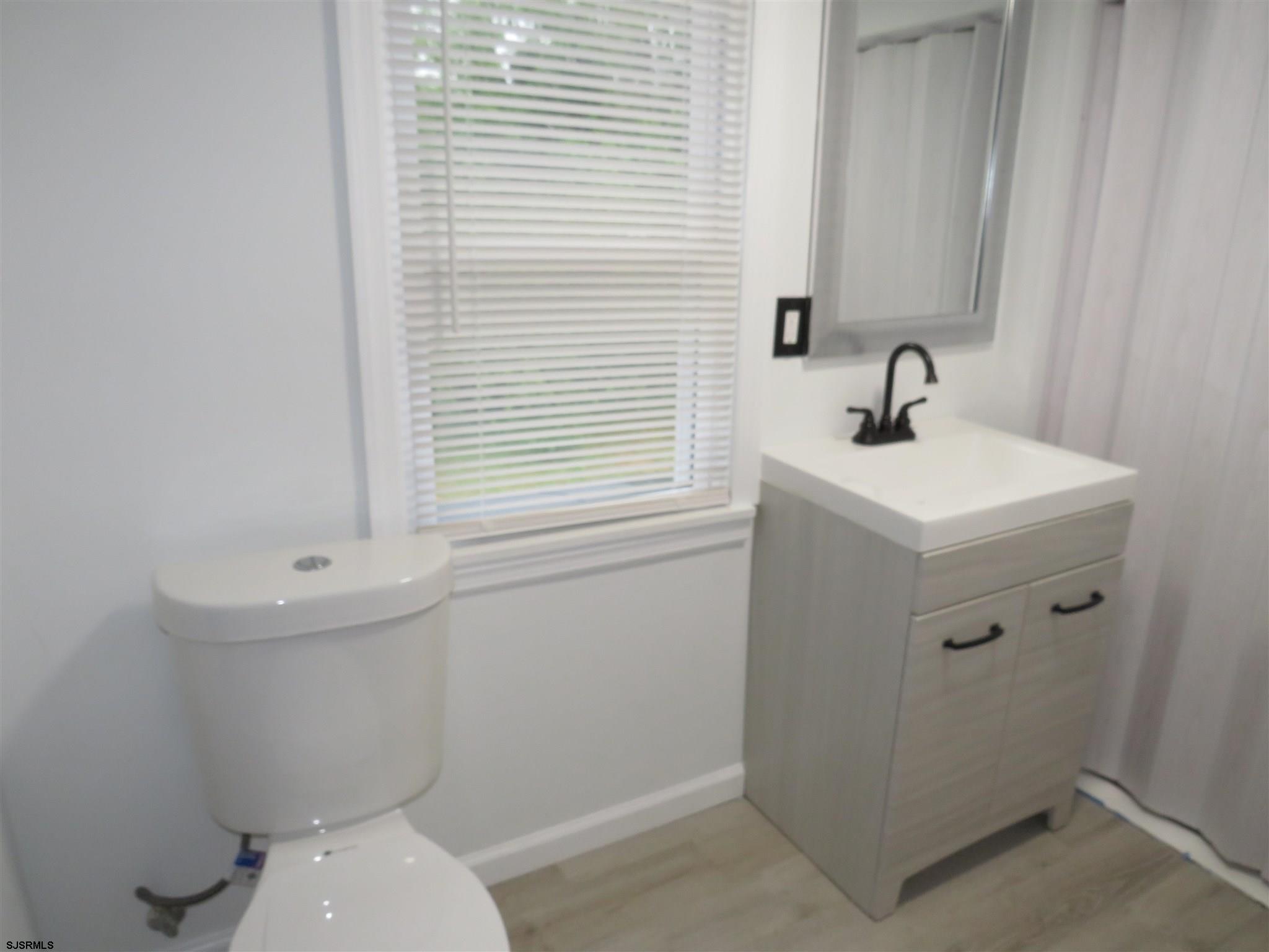 1702 Somers Point Road Egg Harbor Township, NJ 08234 - Photo 22 of 25 a bathroom with a toilet a sink and mirror