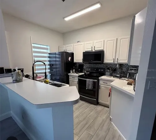 a kitchen with a sink appliances and cabinets