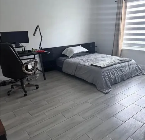 a bedroom with a bed a desk and chair