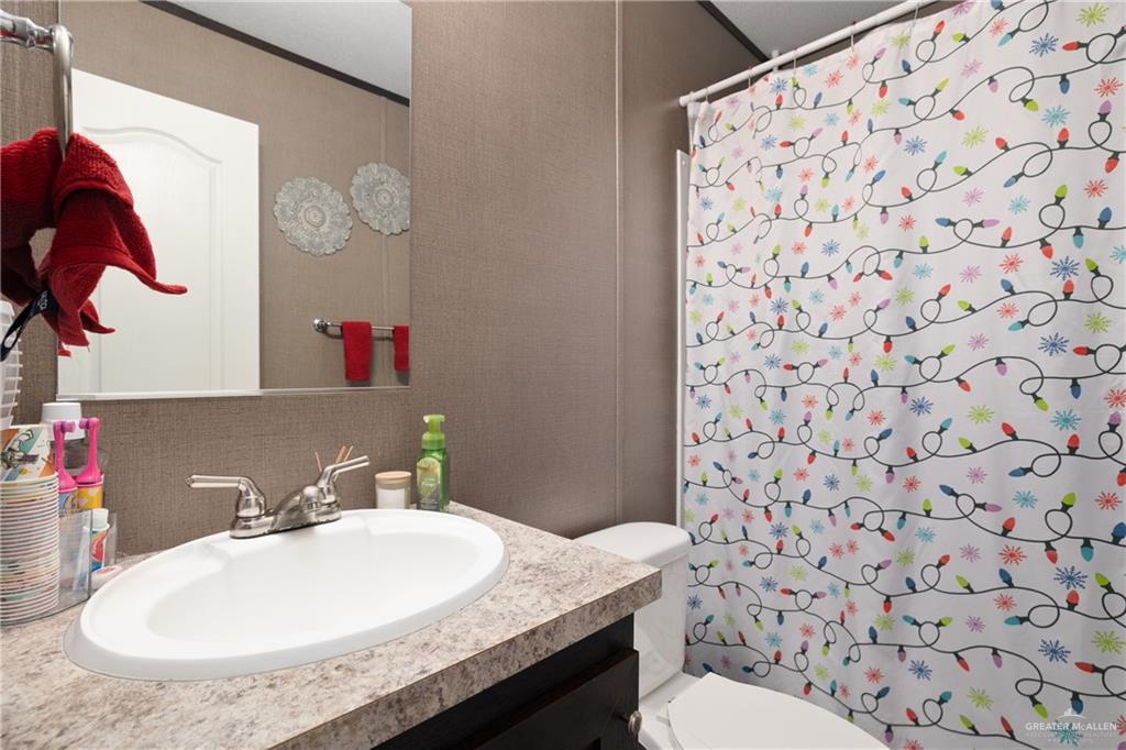 3118 Primrose Drive Weslaco, TX 78596 - Photo 11 of 12 Full bathroom with backsplash, vanity, and curtained shower