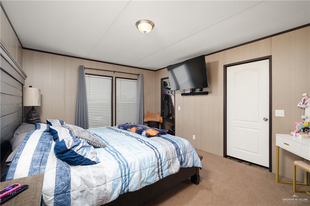 3118 Primrose Drive Weslaco, TX 78596 - Photo 6 of 12 Bedroom with carpet and wood walls