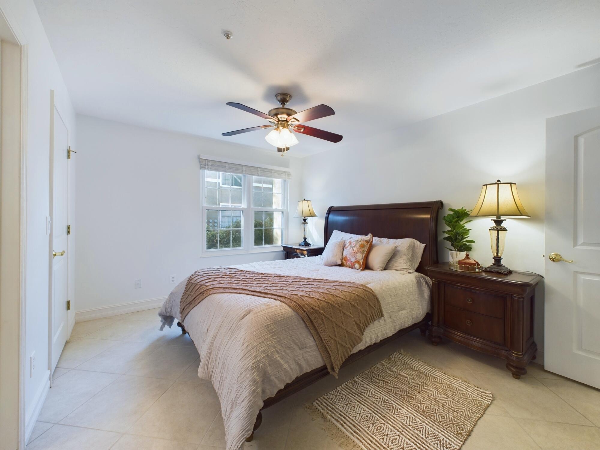 7667 North Wickham Road, Unit 1308 Melbourne, FL 32940 - Photo 13 of 56 a spacious bedroom with a large bed and a chandelier