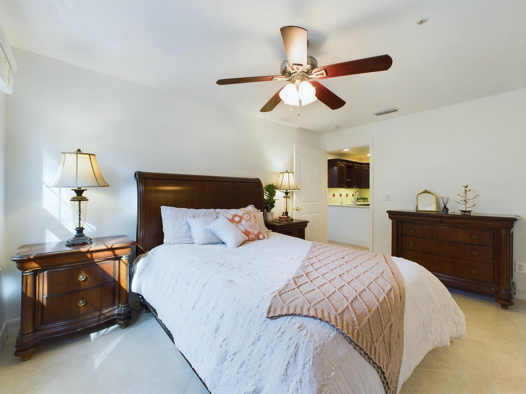 7667 North Wickham Road, Unit 1308 Melbourne, FL 32940 - Photo 15 of 56 a bedroom with a bed and a chandelier