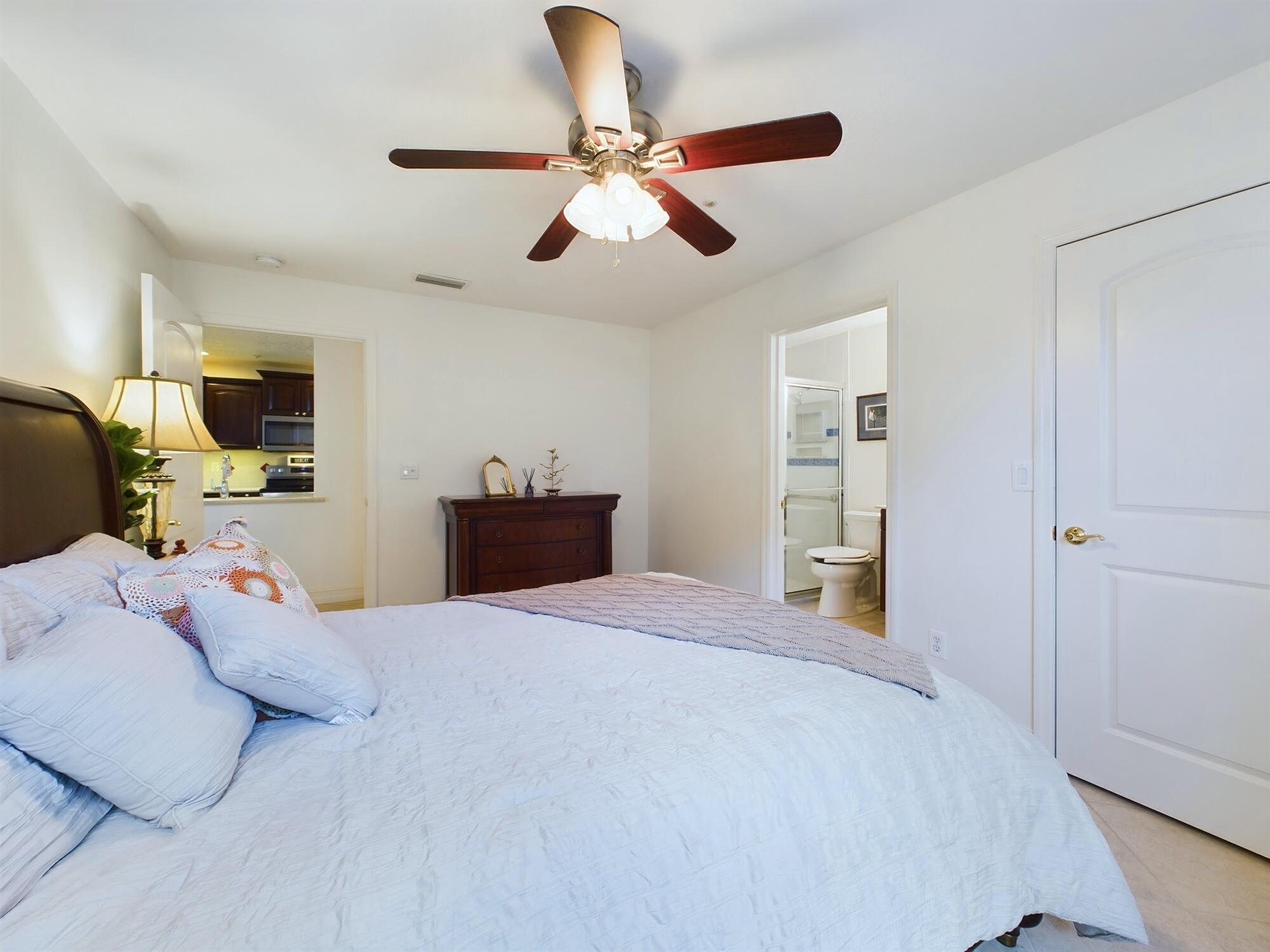7667 North Wickham Road, Unit 1308 Melbourne, FL 32940 - Photo 16 of 56 a bedroom with a bed and a ceiling fan