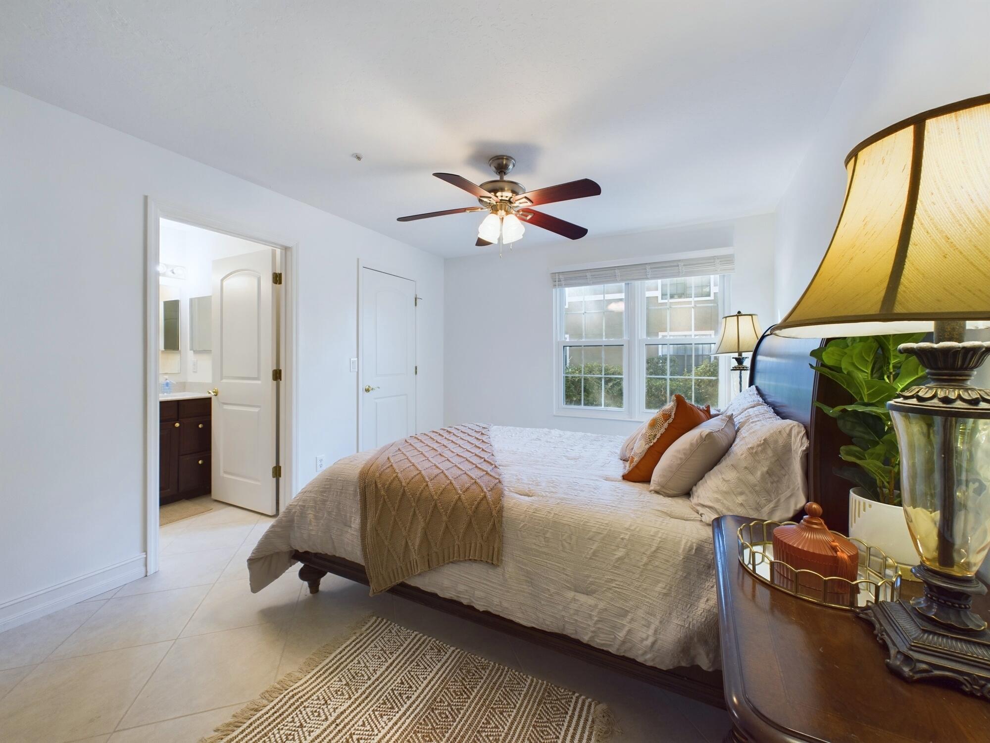 7667 North Wickham Road, Unit 1308 Melbourne, FL 32940 - Photo 19 of 56 a bedroom with a bed and a chandelier
