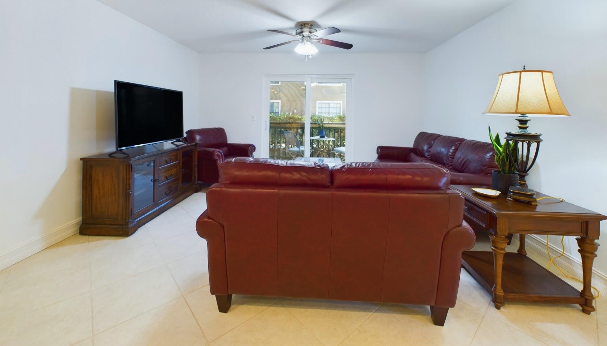 7667 North Wickham Road, Unit 1308 Melbourne, FL 32940 - Photo 25 of 56 a living room with furniture and a flat screen tv