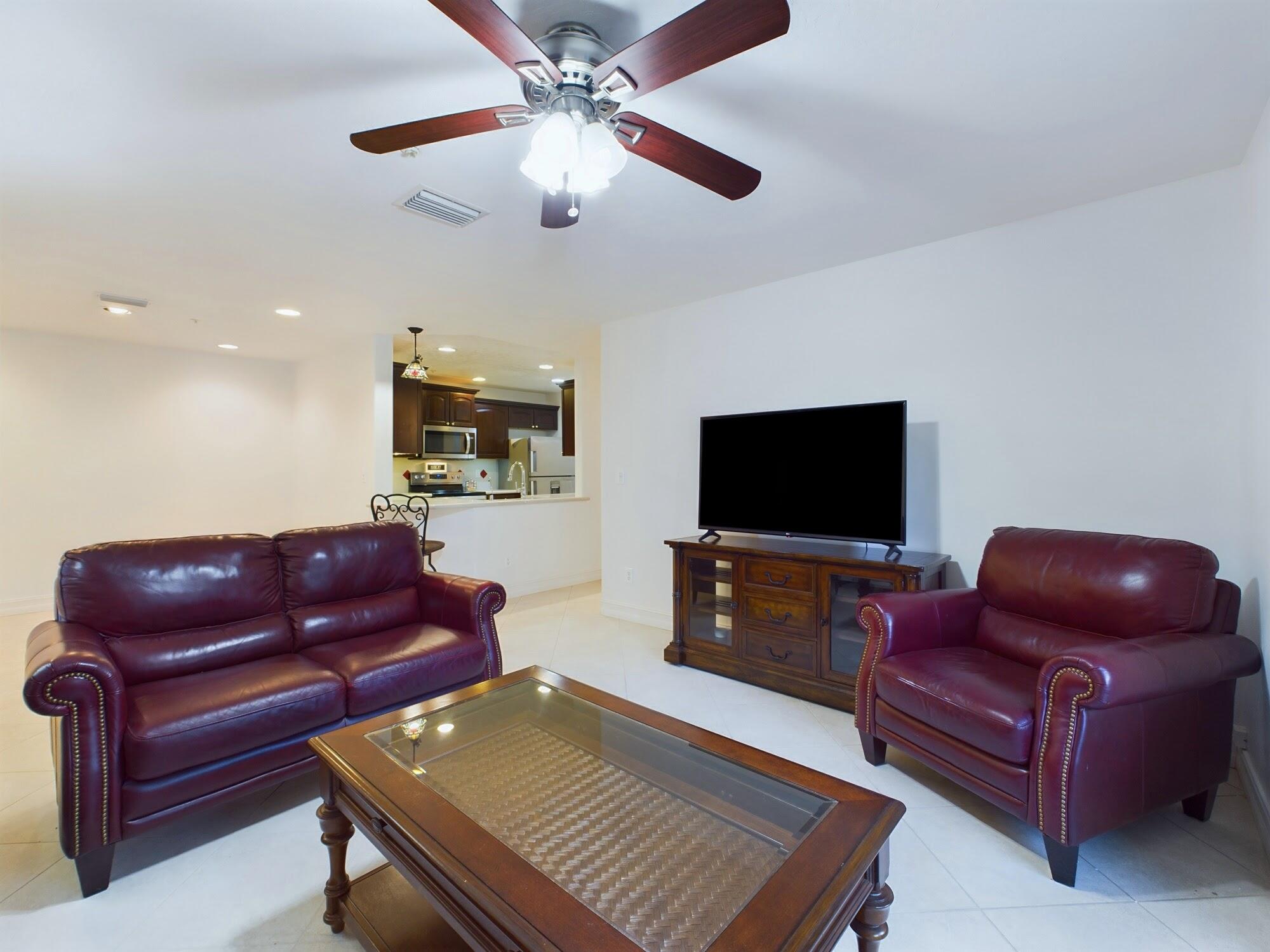 7667 North Wickham Road, Unit 1308 Melbourne, FL 32940 - Photo 27 of 56 a living room with furniture and a flat screen tv