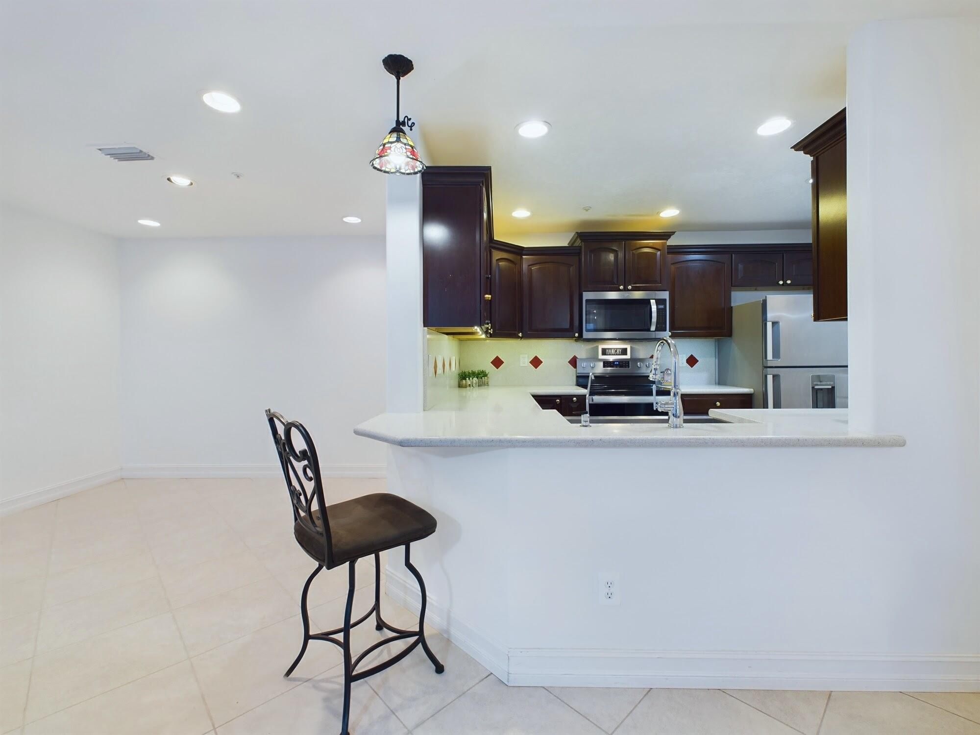 7667 North Wickham Road, Unit 1308 Melbourne, FL 32940 - Photo 33 of 56 a kitchen with stainless steel appliances a refrigerator and a stove top oven with wooden floor