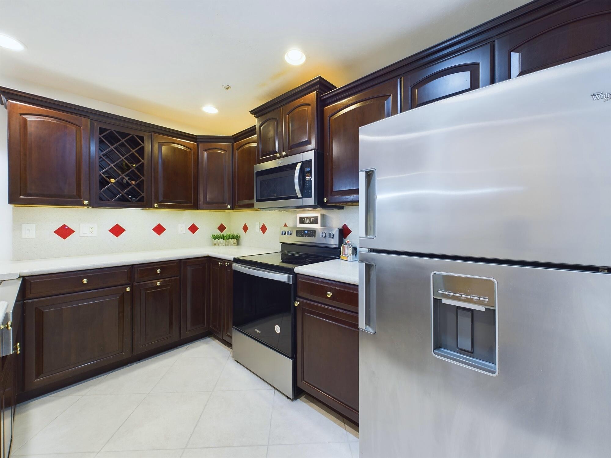 7667 North Wickham Road, Unit 1308 Melbourne, FL 32940 - Photo 10 of 56 a kitchen with stainless steel appliances granite countertop a refrigerator and a stove top oven