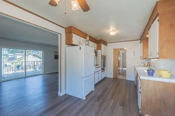 a kitchen with stainless steel appliances granite countertop a sink and dishwasher a refrigerator with wooden floor