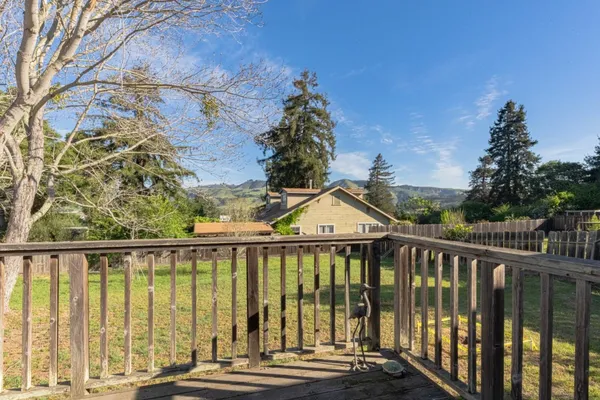 an empty room with wooden floor fireplace and window