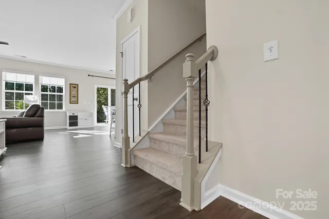 a view of staircase and living room with wooden floor and a large window