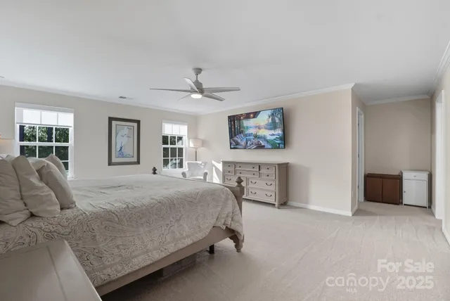 a bedroom with a large bed and a chandelier