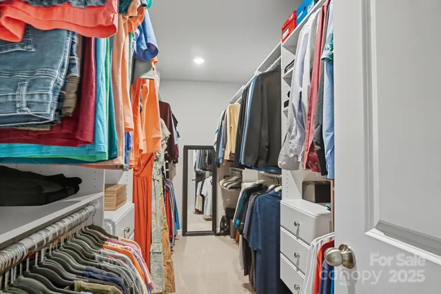 a view of walk in closet with clothes and shoes