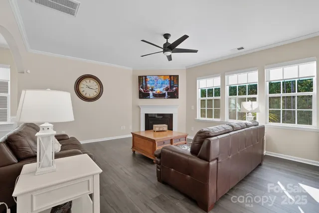 a living room with furniture a fireplace and a large window