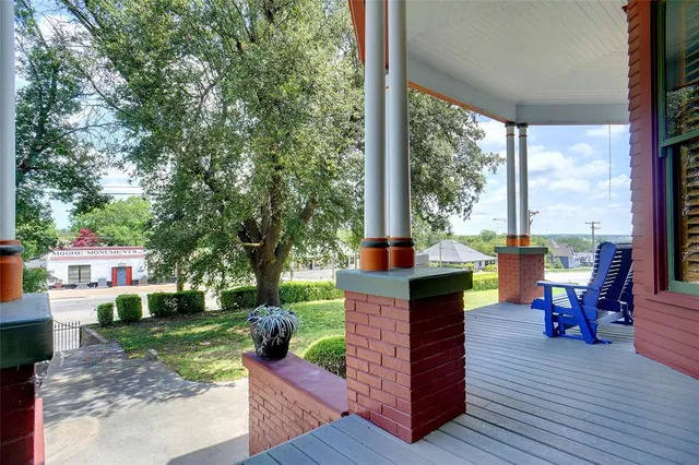a view of a patio with table and chairs potted plants and a large tree