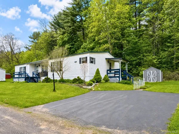 a view of a house with backyard and trees