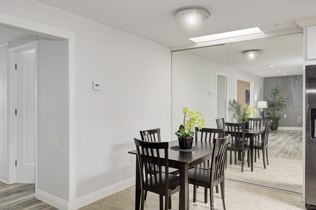 245 Calle Aragon, Unit C Laguna Woods, CA 92637 - Photo 13 of 32 a view of a dining room with furniture and a potted plant