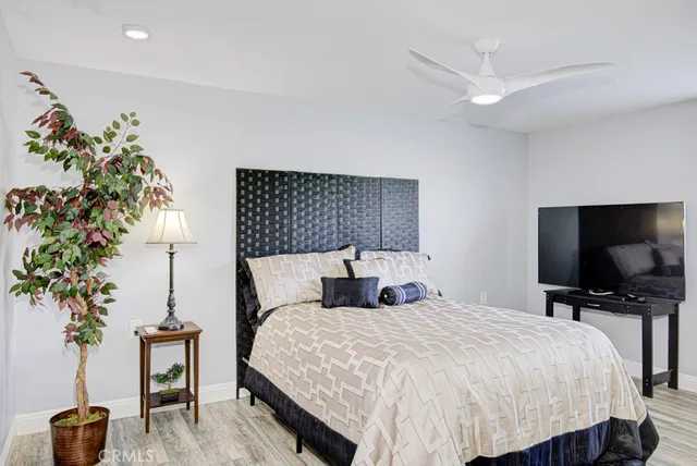 a bedroom with a large bed and a flat tv screen on dresser