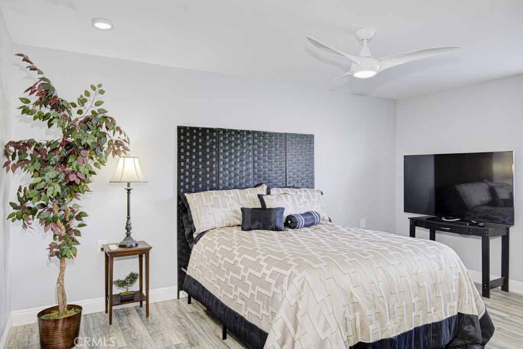245 Calle Aragon, Unit C Laguna Woods, CA 92637 - Photo 17 of 32 a bedroom with a large bed and a flat tv screen on dresser