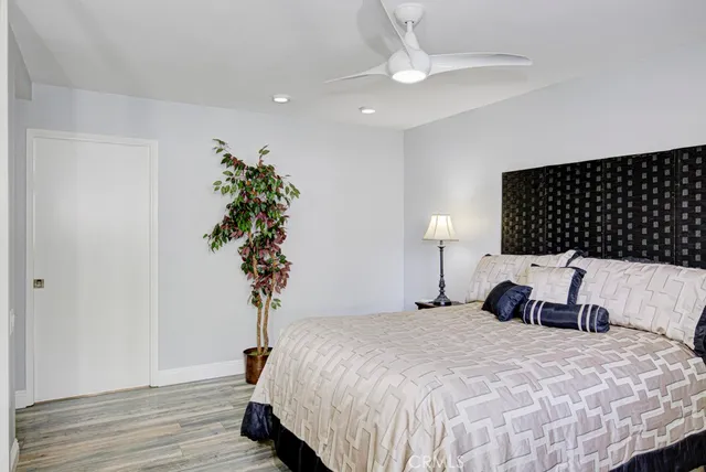 a bedroom with a bed and a potted plant