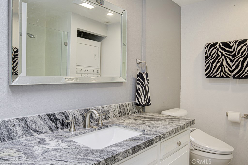 245 Calle Aragon, Unit C Laguna Woods, CA 92637 - Photo 21 of 32 a bathroom with a granite countertop sink and a mirror