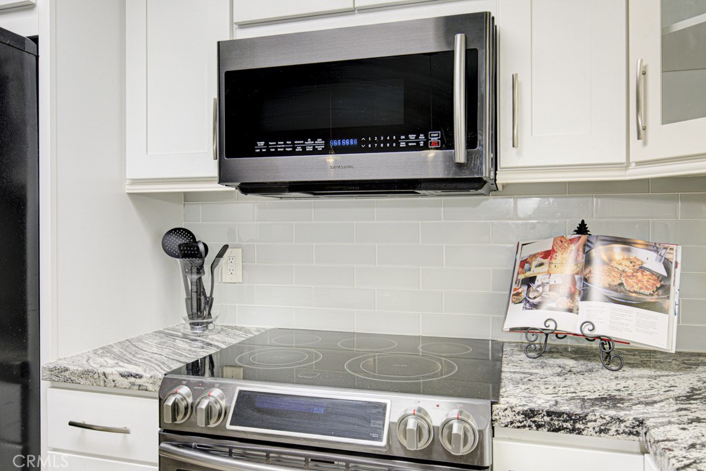 245 Calle Aragon, Unit C Laguna Woods, CA 92637 - Photo 3 of 32 a kitchen with a stove and a microwave