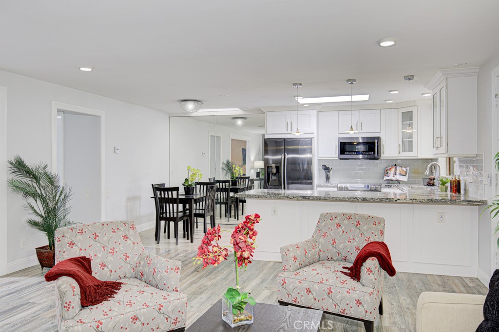 245 Calle Aragon, Unit C Laguna Woods, CA 92637 - Photo 9 of 32 a kitchen with stainless steel appliances granite countertop a dining table cabinets a sink and a window