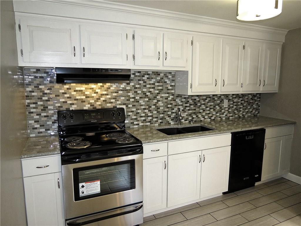 A Mosaic glass backsplash and composite granite double bowl sink adds flair to the room.