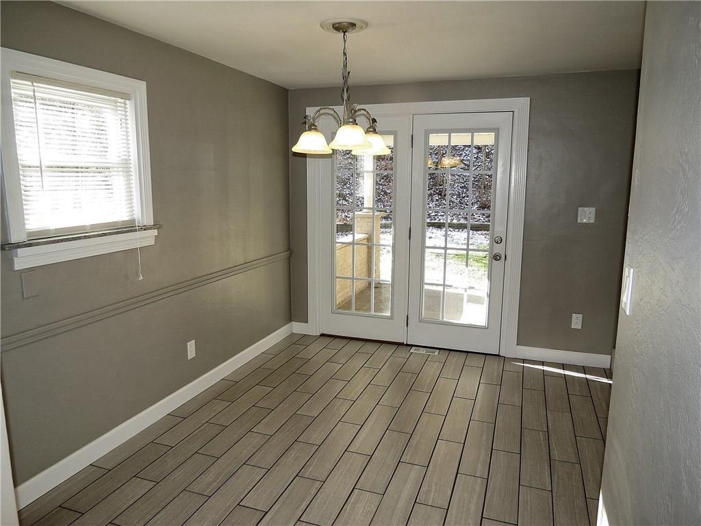 French doors transition the kitchen onto a covered cement patio.