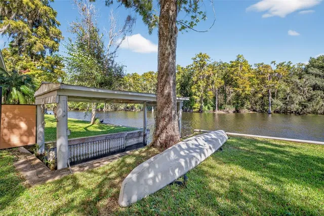 a view of a deck with a big yard and a large tree