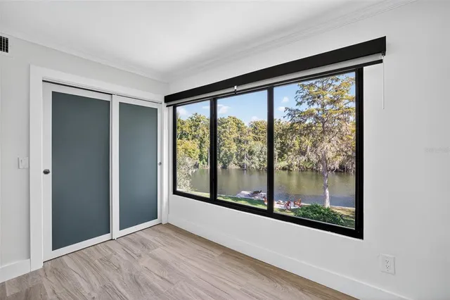 an empty room with wooden floor and windows