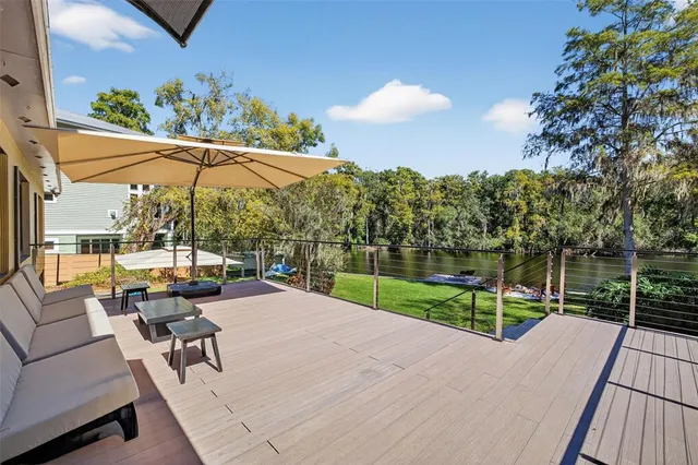 a view of a patio with couches table and chairs under an umbrella