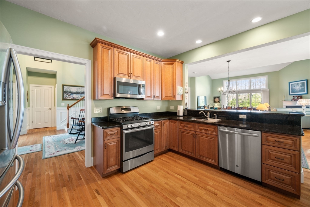 96 Walden Way, Unit 52 Milford, MA 01757 - Photo 4 of 23 a kitchen with stainless steel appliances granite countertop wooden cabinets a sink a stove a dining table and chairs