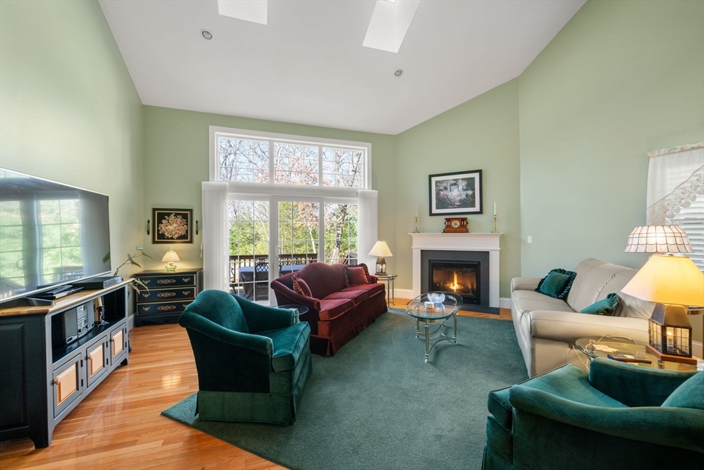 96 Walden Way, Unit 52 Milford, MA 01757 - Photo 7 of 23 a living room with furniture a fireplace and a large window