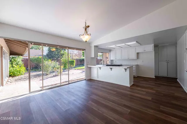 a view of a kitchen with wooden floor and a large window